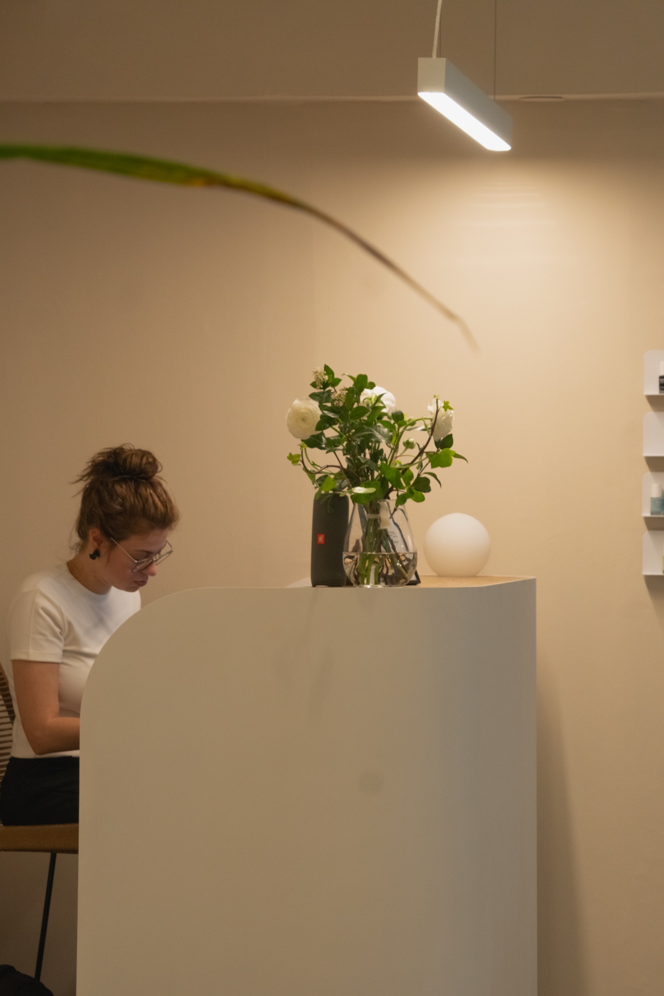 Counter with linear pendant light and white flowers